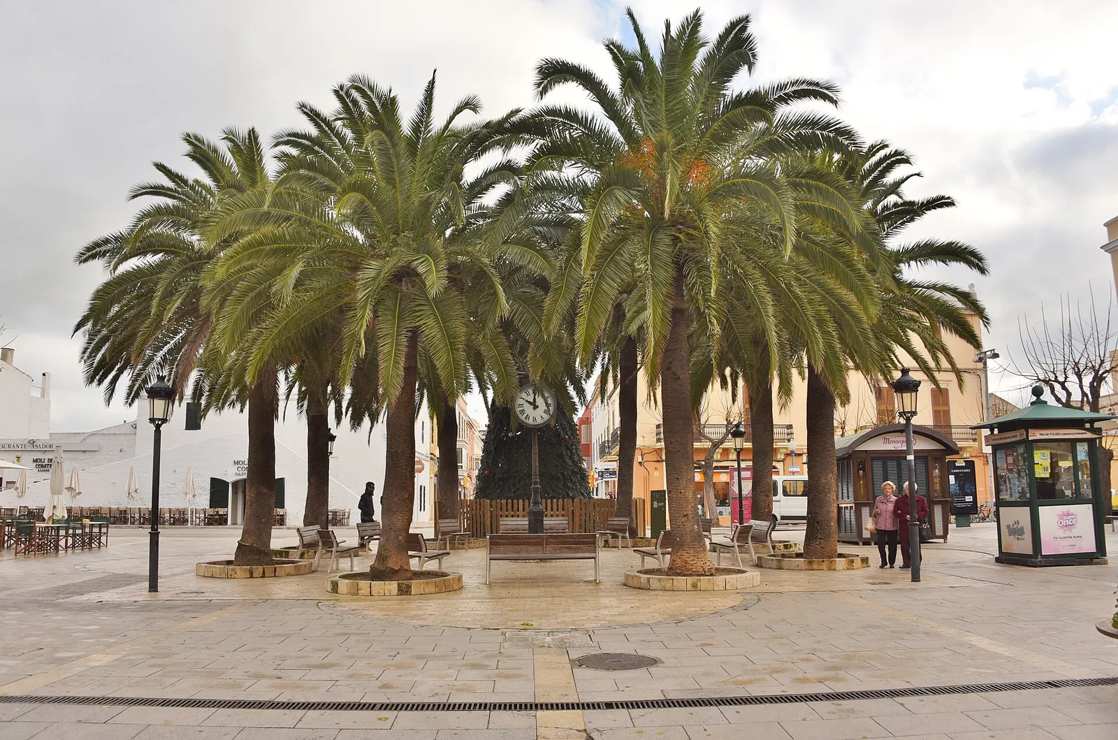 A Plaça d'Alfons III de Ciutadella, com as suas palmeiras e o relógio