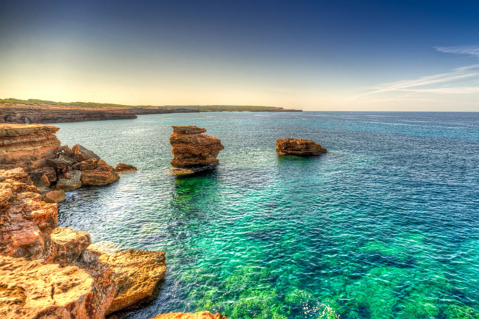 La costa de Can Marroig, en Formentera, con el agua clara sobre la roca baja
