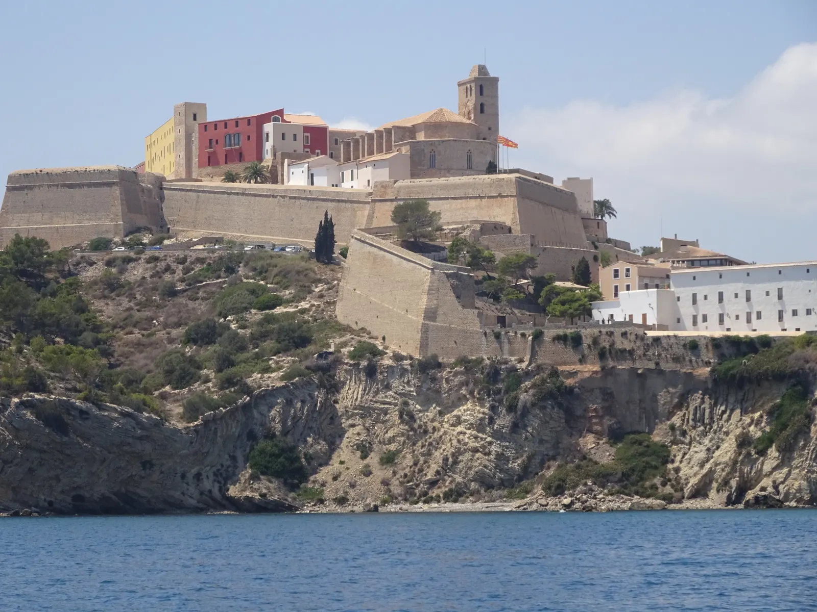 Dalt Vila vista desde el mar: la muralla renacentista sobre el acantilado, con la catedral y el castillo en lo alto