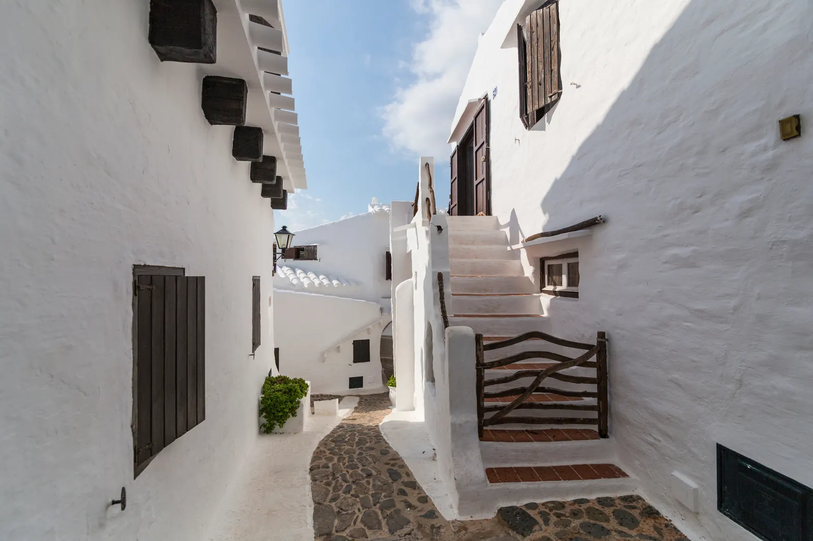 Whitewashed alley with a white staircase in Binibeca Vell, in south-eastern Menorca.
