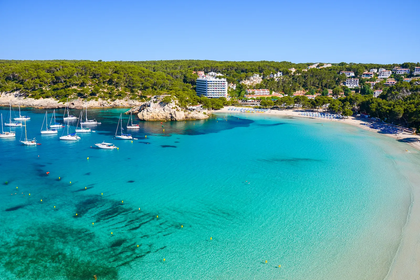 la bahía turquesa de Cala Galdana con veleros y pinar, en el municipio de Ferreries, Menorca