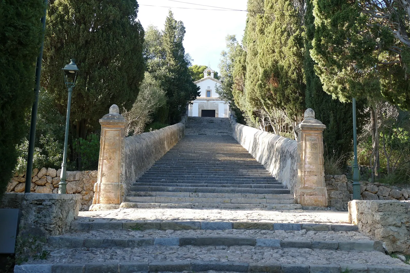 La scalinata del Calvari di Pollença, fiancheggiata da cipressi, con la cappella bianca in cima
