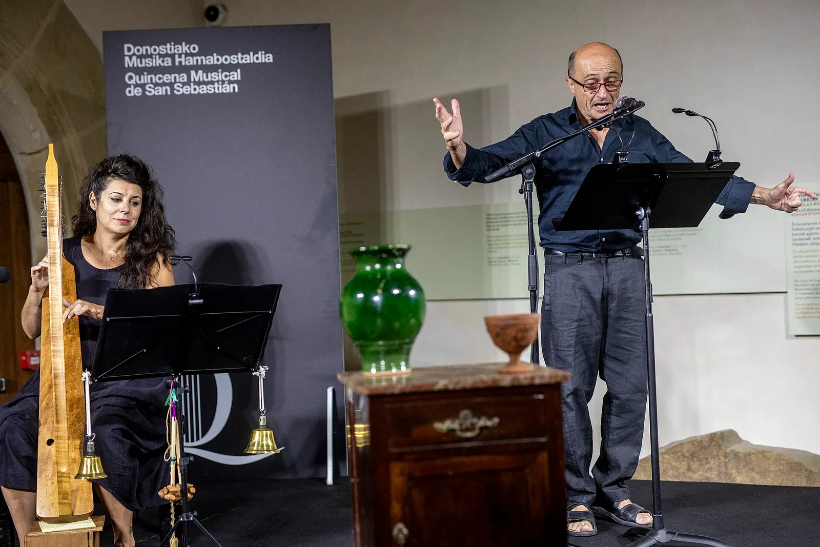 Pepe Viyuela sul palco, in piedi davanti a un leggio, durante una lettura scenica