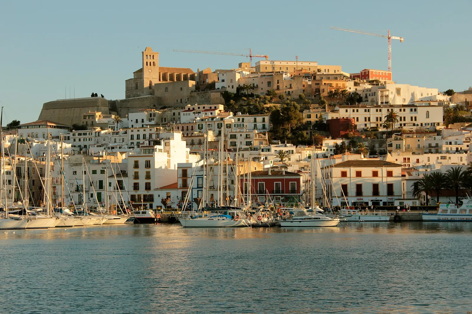 La ciudad de Ibiza y Dalt Vila al atardecer, con el puerto y las barcas en primer plano