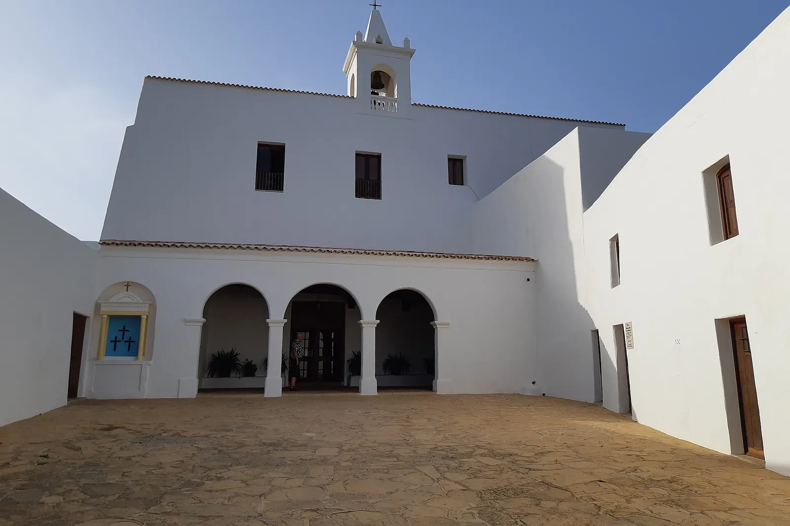 La iglesia fortificada de Sant Miquel de Balansat, blanca, con su porche de arcos y el patio delante