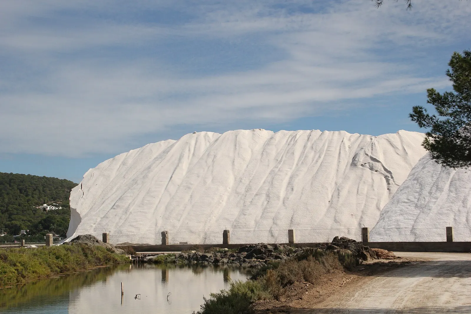 Una montaña de sal blanca junto a los estanques de las salinas de Ibiza