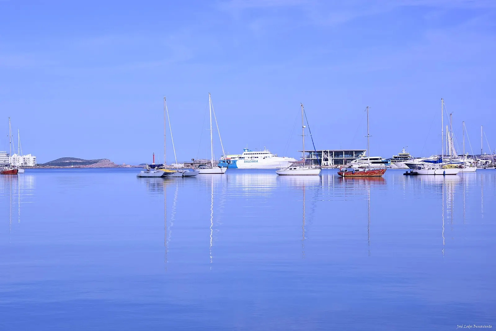 La bahía de Sant Antoni de Portmany en calma, con veleros fondeados y el mar como un espejo
