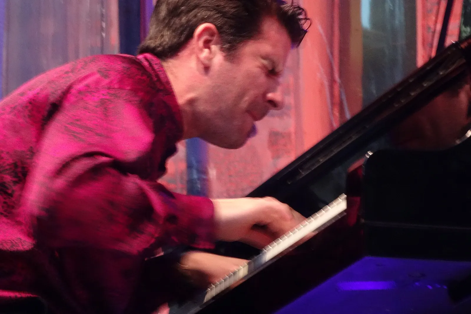 Il pianista Marco Mezquida suona un pianoforte a coda in concerto, con luce rosata
