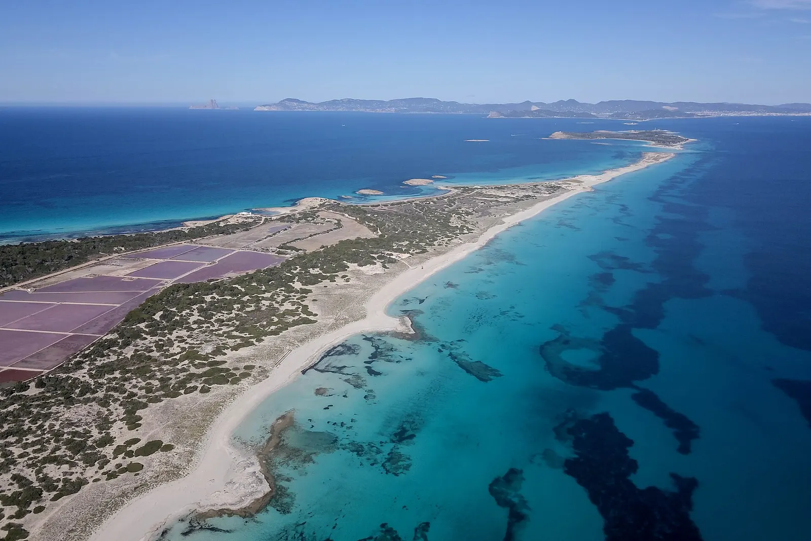 Vista aérea del parque natural de ses Salines, con los estanques rosados y la lengua de arena de ses Illetes