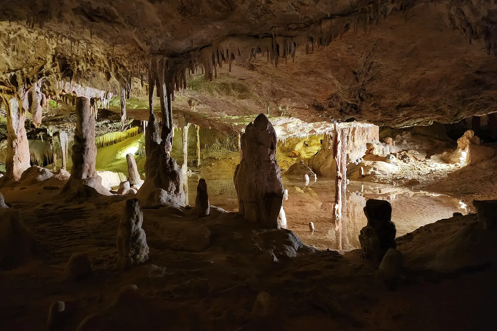 Estalactitas y estalagmitas iluminadas en el interior de la Cova de Can Marçà