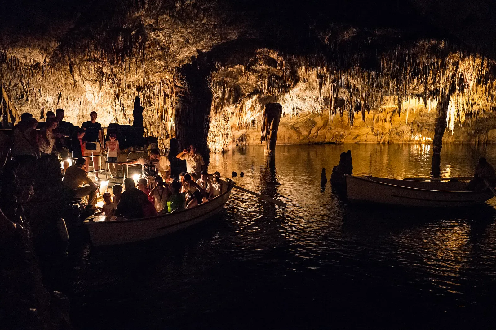Barcas con visitantes sobre el lago Martel, en las Coves del Drac, bajo las estalactitas iluminadas