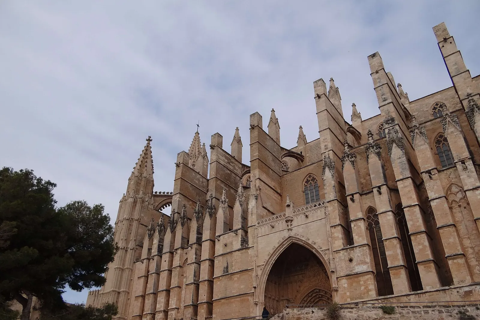 La facciata gotica della Cattedrale di Palma, con i suoi contrafforti e pinnacoli, sotto un cielo azzurro