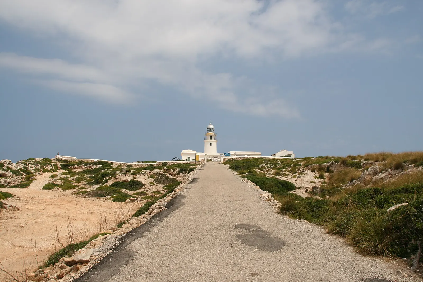 Il sentiero che porta al faro di Cavalleria, nel nord di Minorca, tra la macchia mediterranea e sotto un cielo nuvoloso