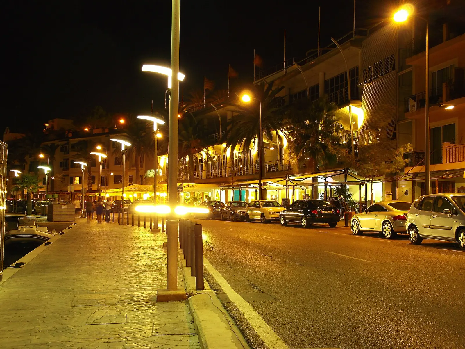 O passeio do porto de Maó iluminado à noite, com as esplanadas abertas