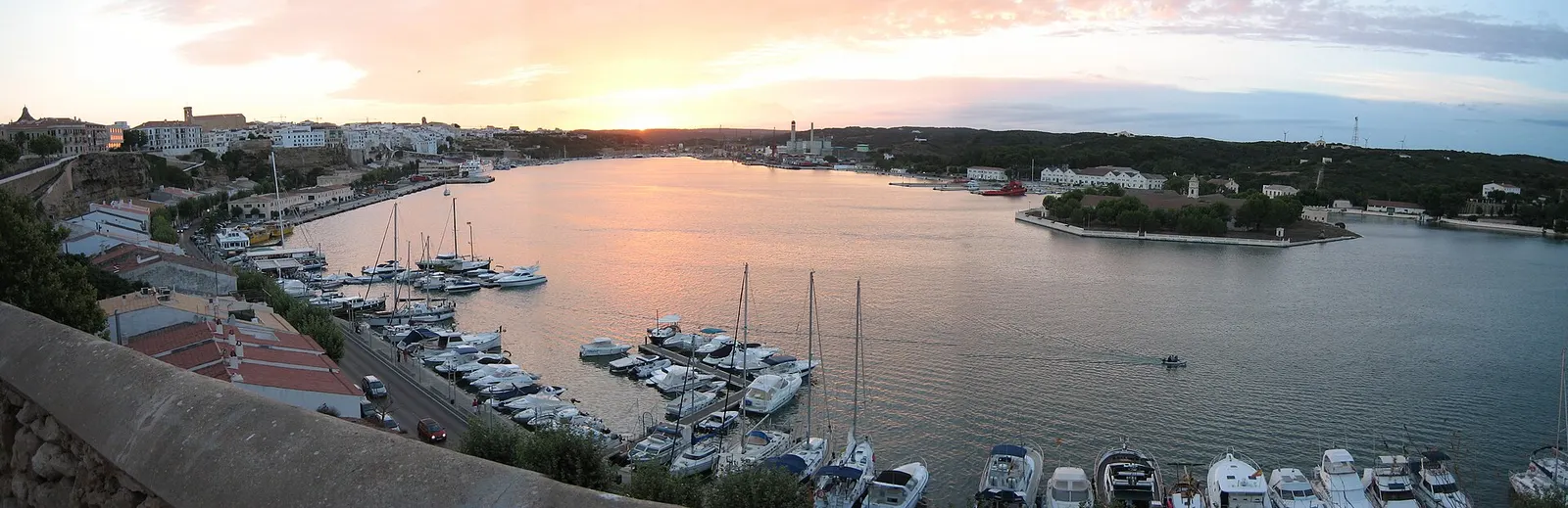 Veleros amarrados en el puerto de Maó con el cielo del atardecer
