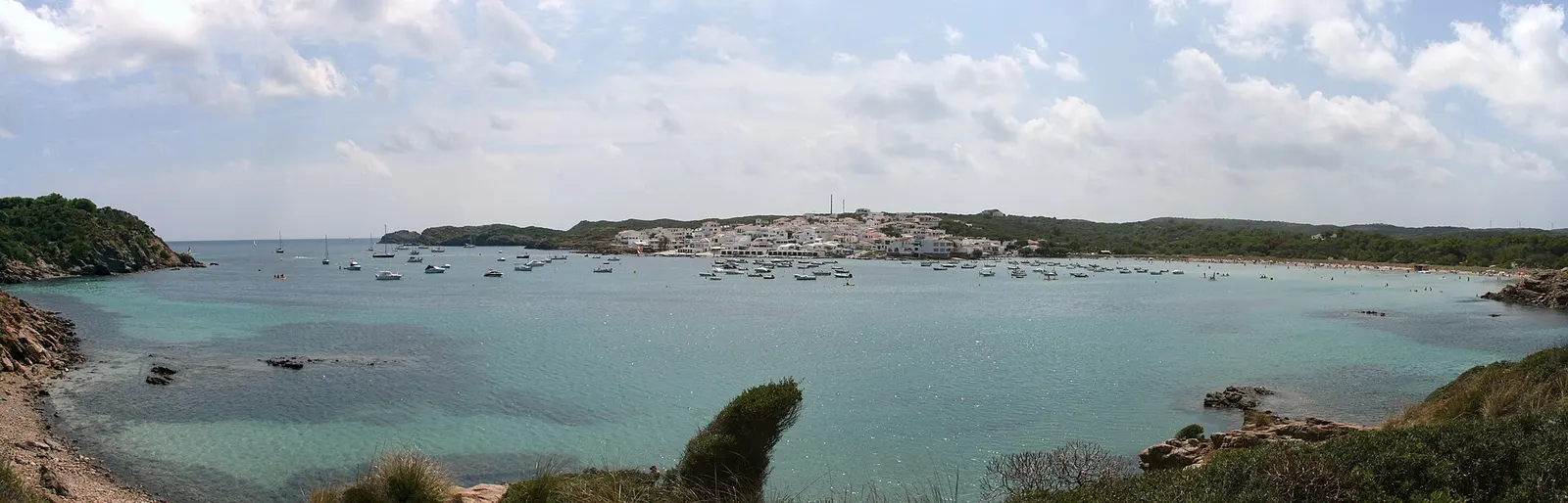 A baía des Grau com a povoação branca ao fundo e as barcas fundeadas