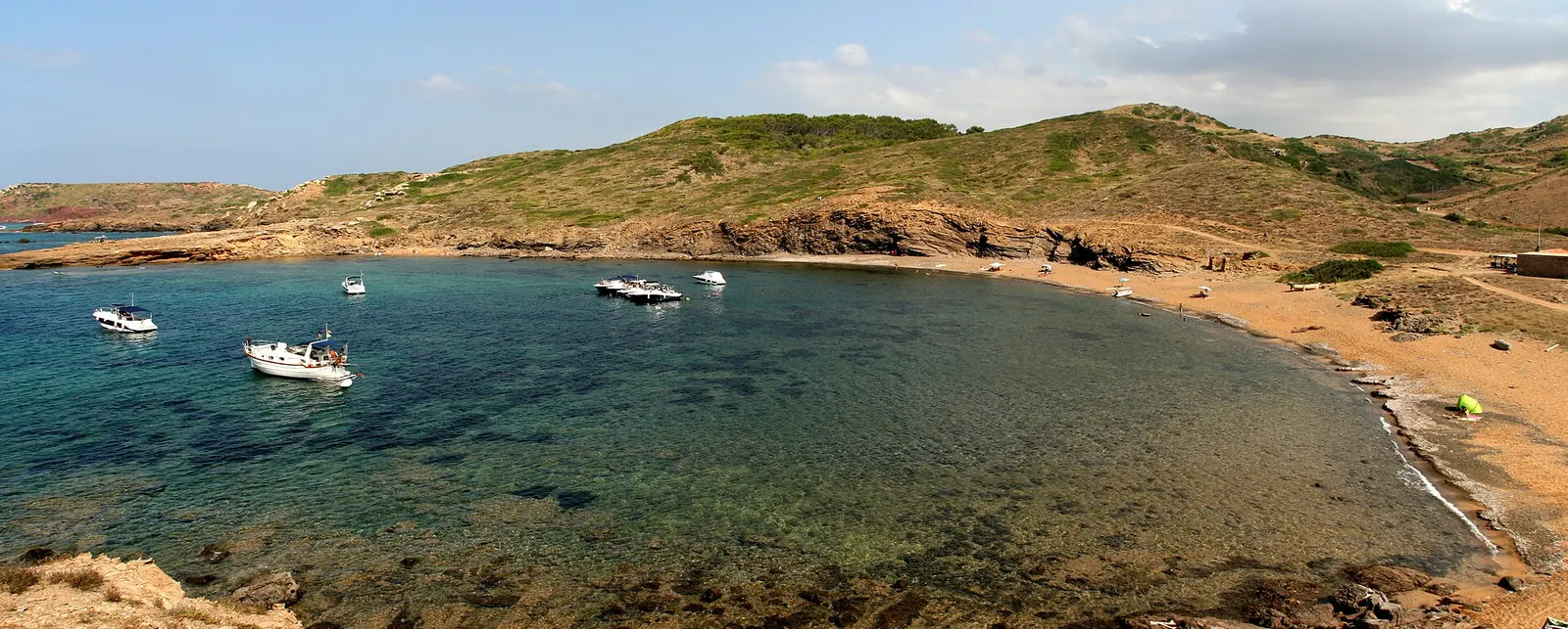 Agua transparente sobre el fondo rocoso de una cala de la costa norte