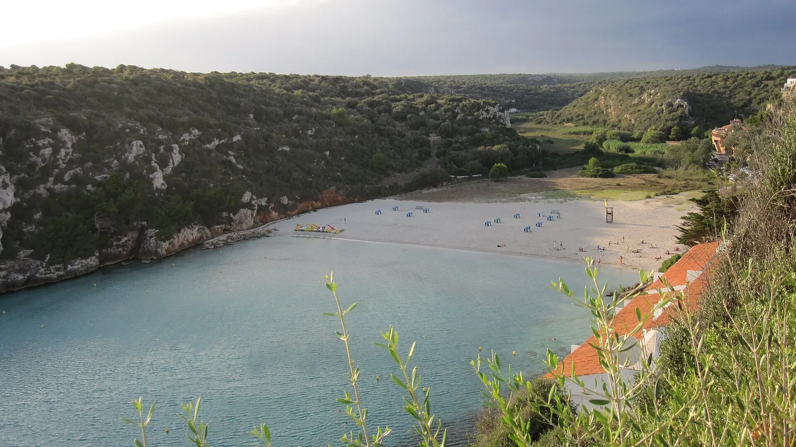 La cala de Cala en Porter con su playa al fondo del barranco, entre acantilados