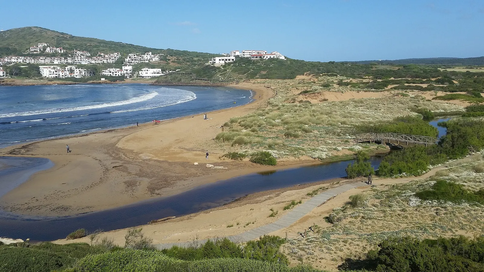 La playa de Cala Tirant con la albufera detrás y las casas blancas en la loma
