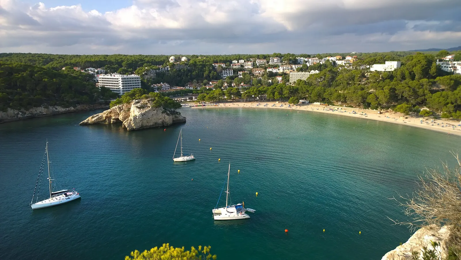 Cala Galdana vista da falésia, com um veleiro fundeado na entrada da enseada