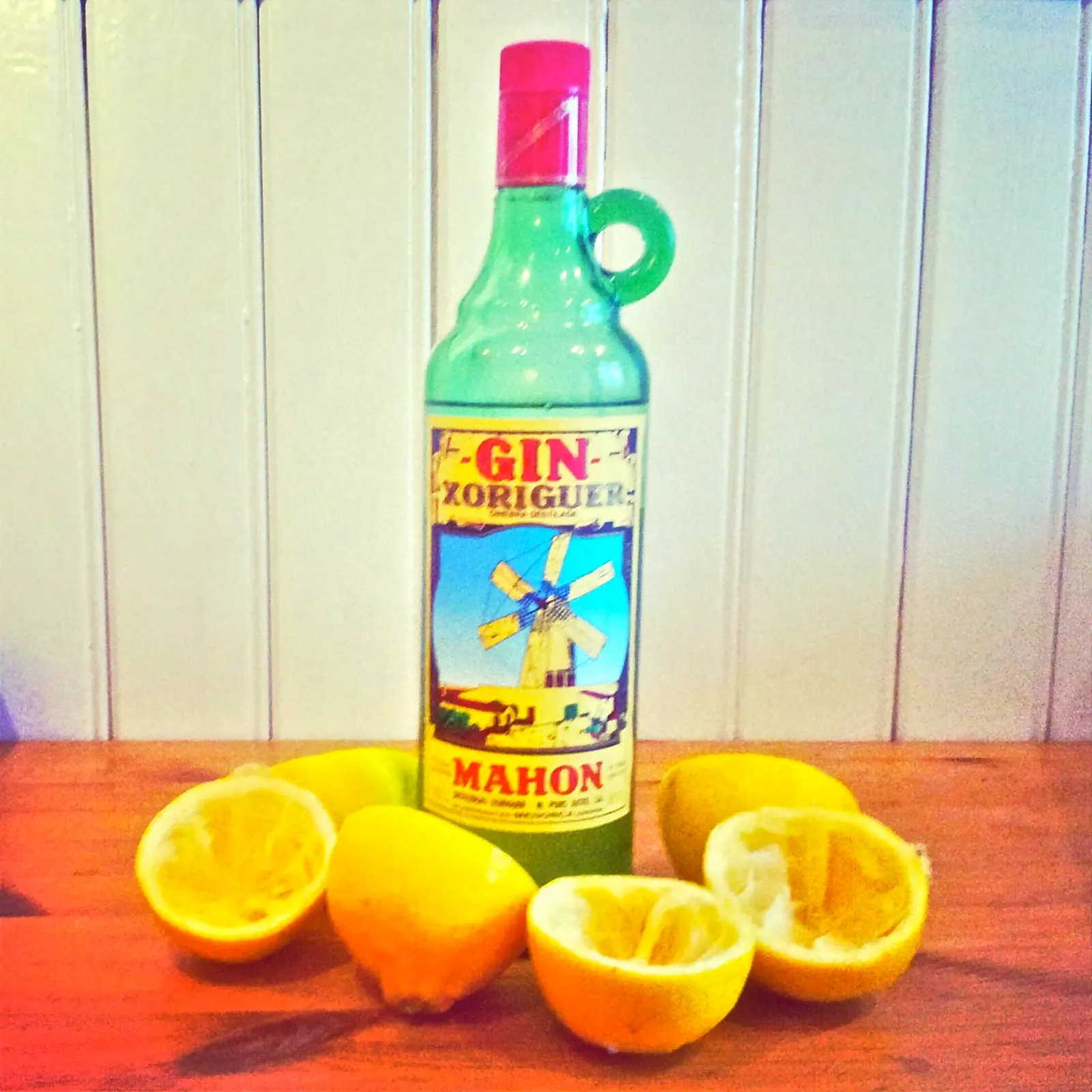 Uma garrafa de gin Xoriguer de Maó junto a limões partidos