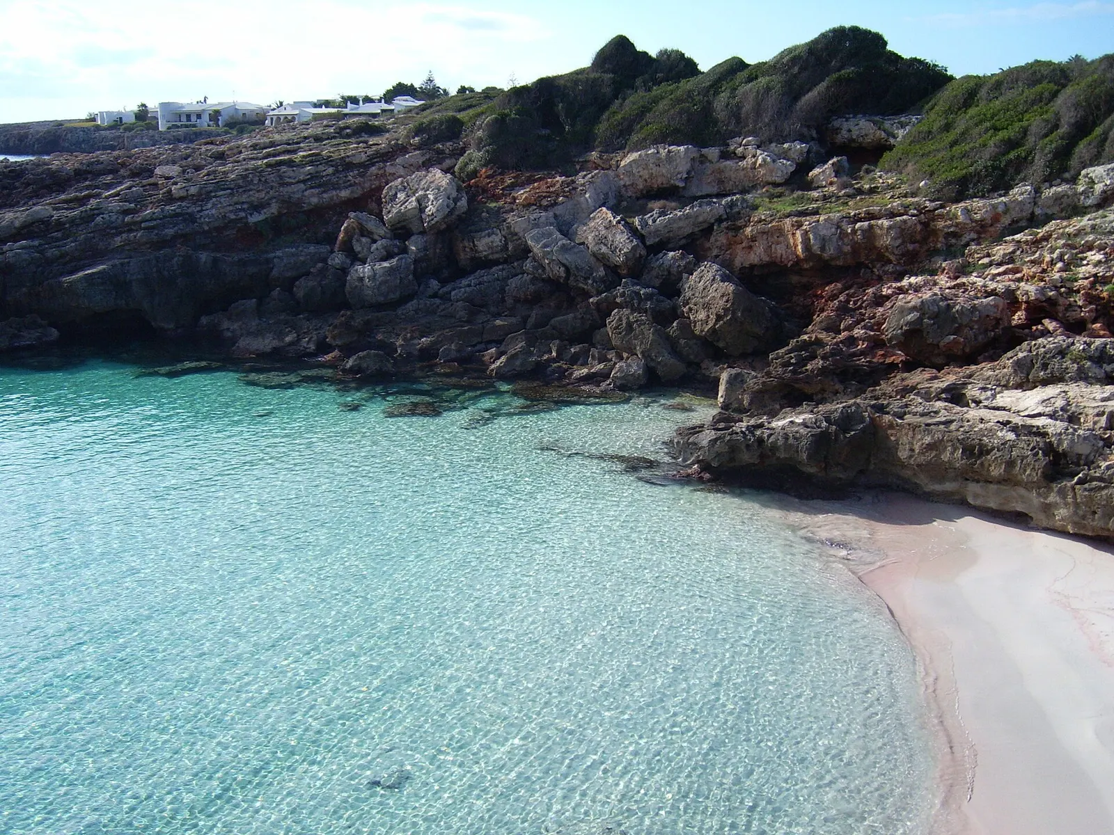 Es Caló Blanc: uma pequena enseada de areia clara e água transparente entre rocha baixa