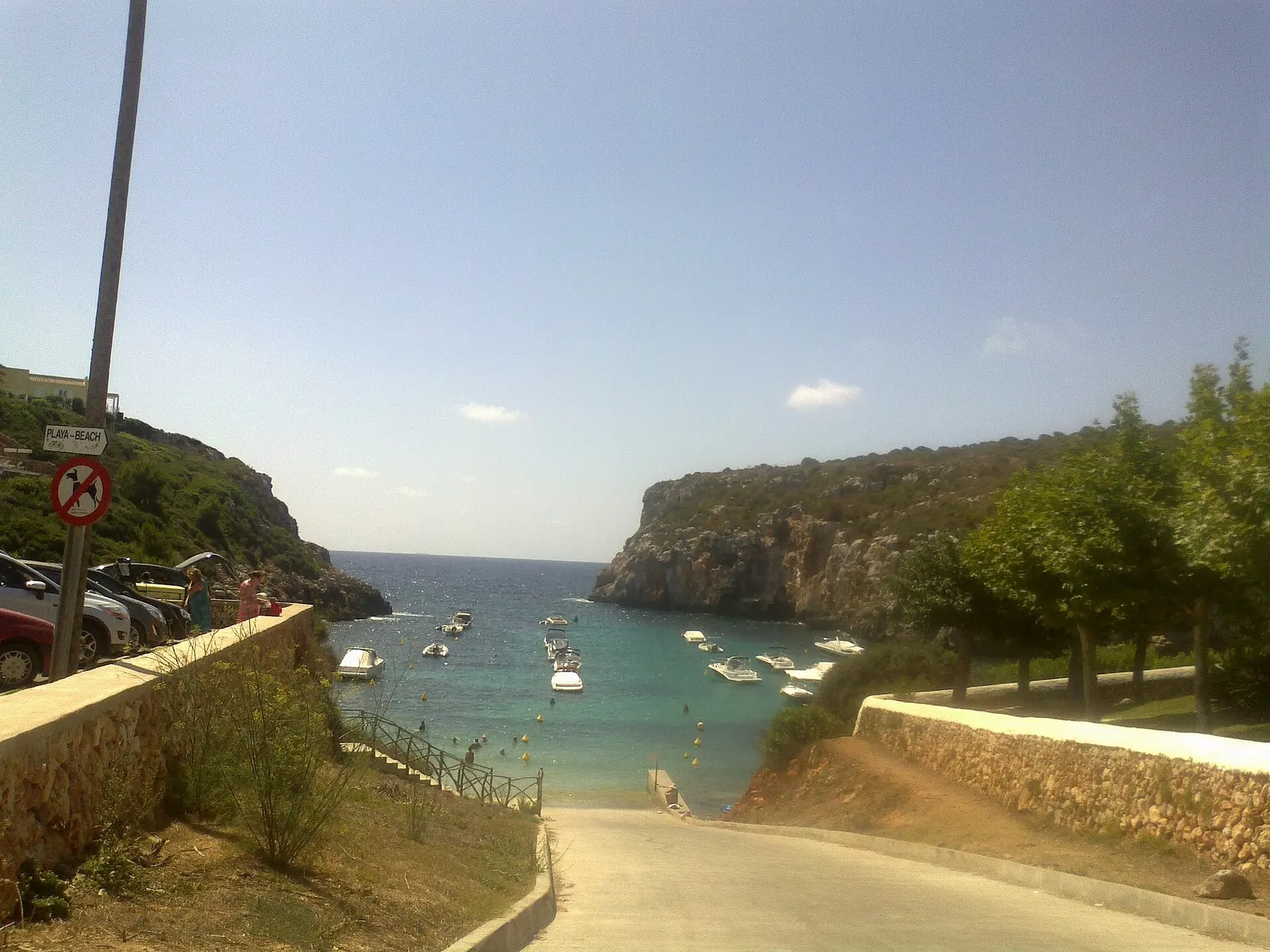 La cala de Es Canutells con las barcas fondeadas y el acantilado cerrando la entrada
