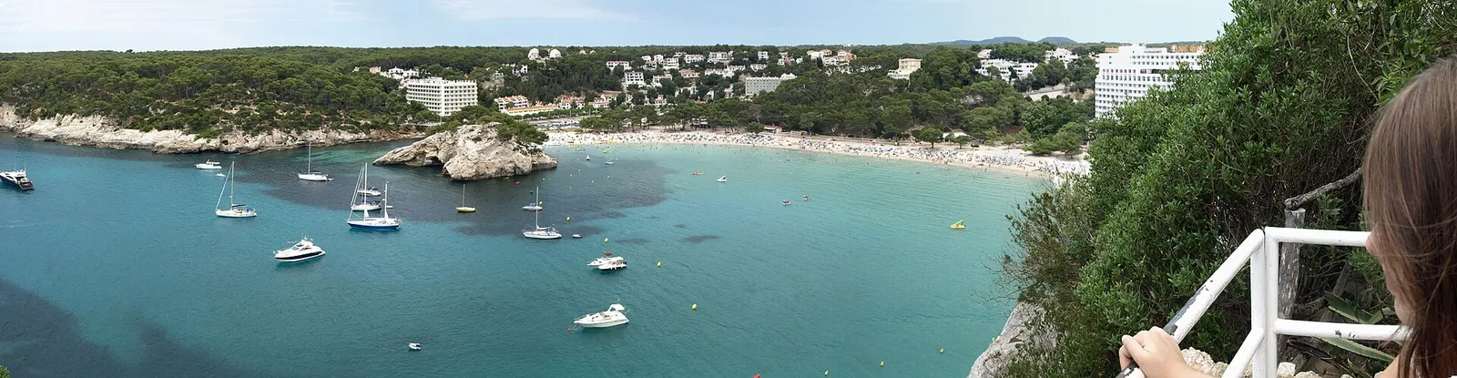 La bahía de Cala Galdana con las embarcaciones fondeadas y los edificios sobre la playa