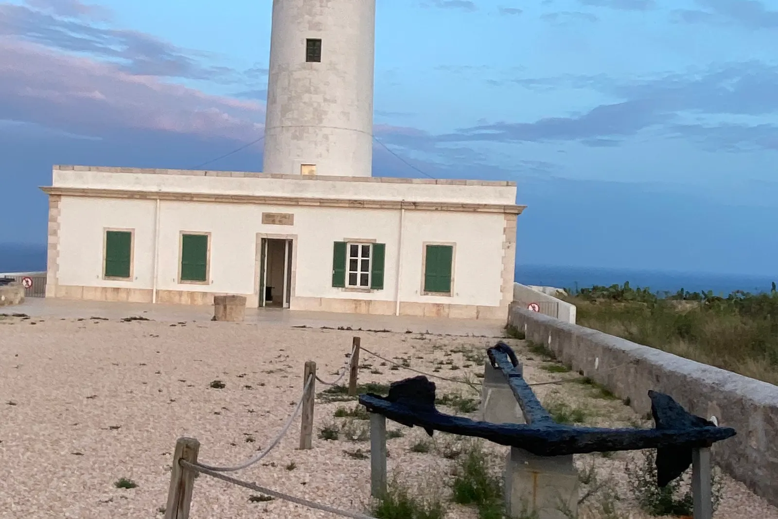 El faro blanco de la Mola, en el extremo oriental de Formentera, con su casa baja al pie