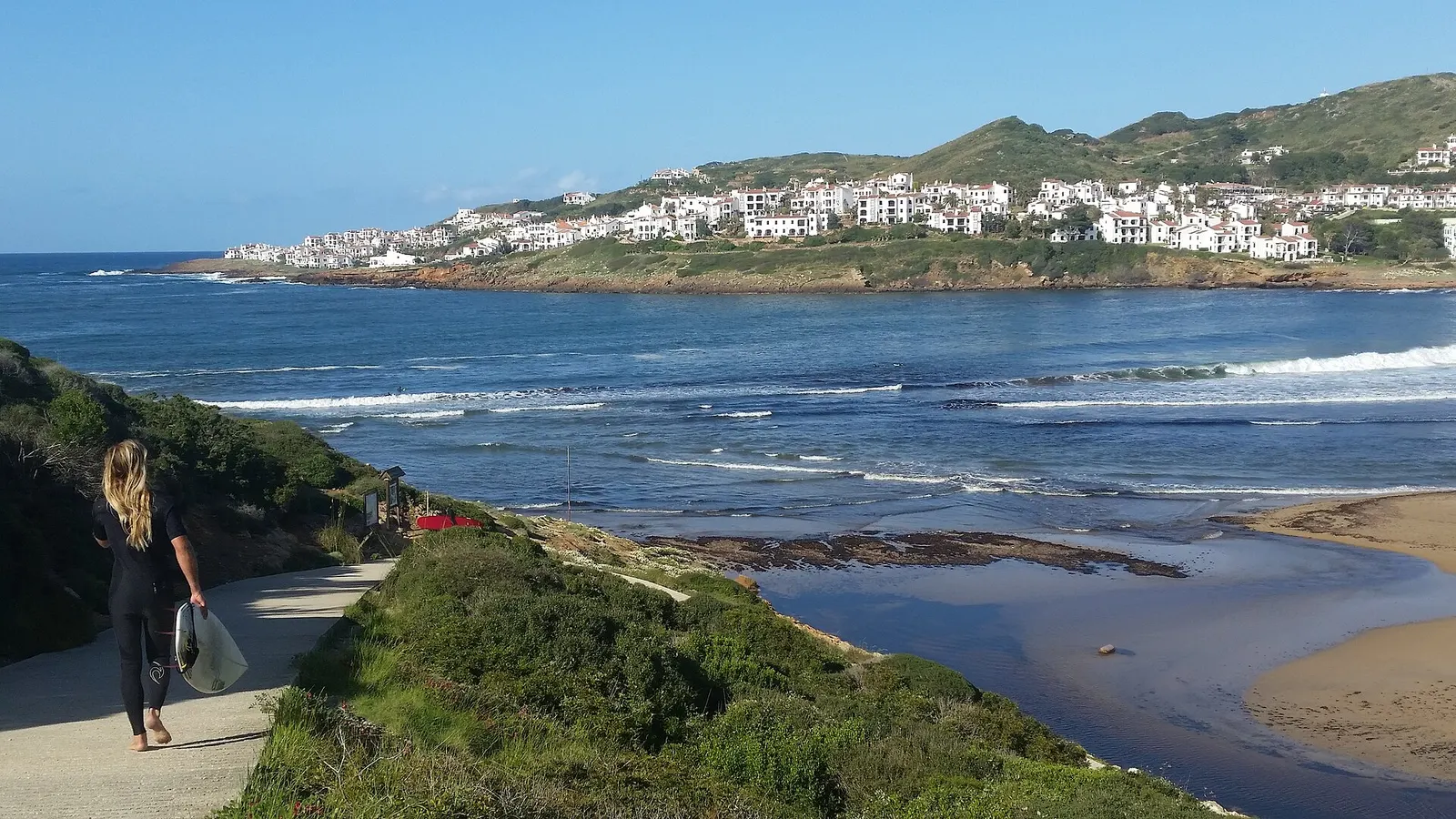 Die Küste von Cala Tirant mit weißen Häusern auf der Anhöhe