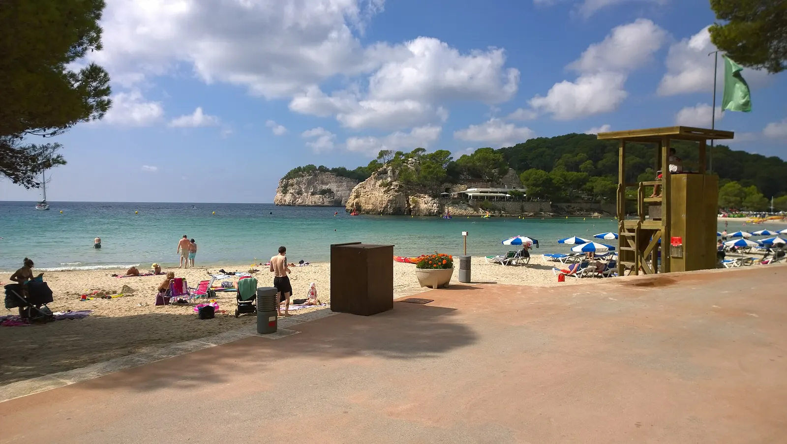 La orilla de Cala Galdana con el acantilado horadado al fondo