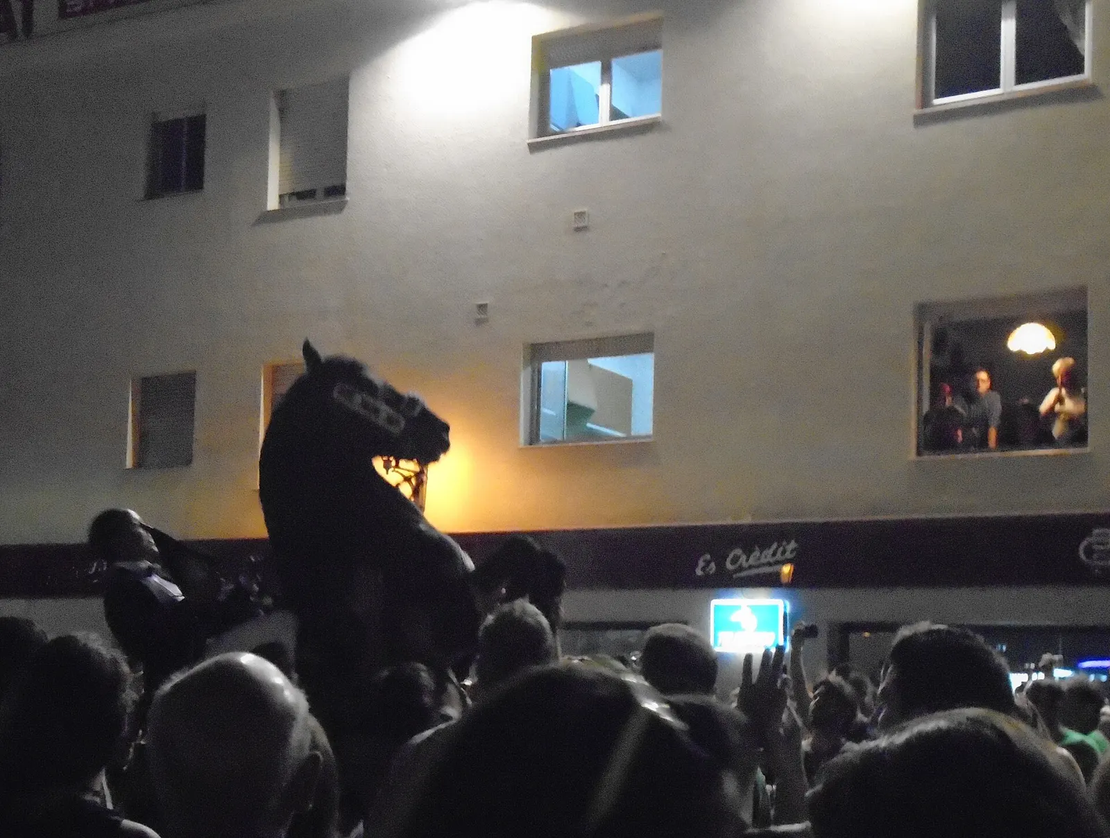 Un caballo negro encabritado entre la gente, en el jaleo nocturno de Llucmaçanes