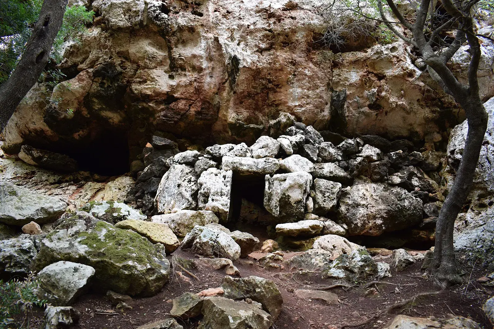 La entrada de una cueva funeraria de Cales Coves, entre bloques de piedra