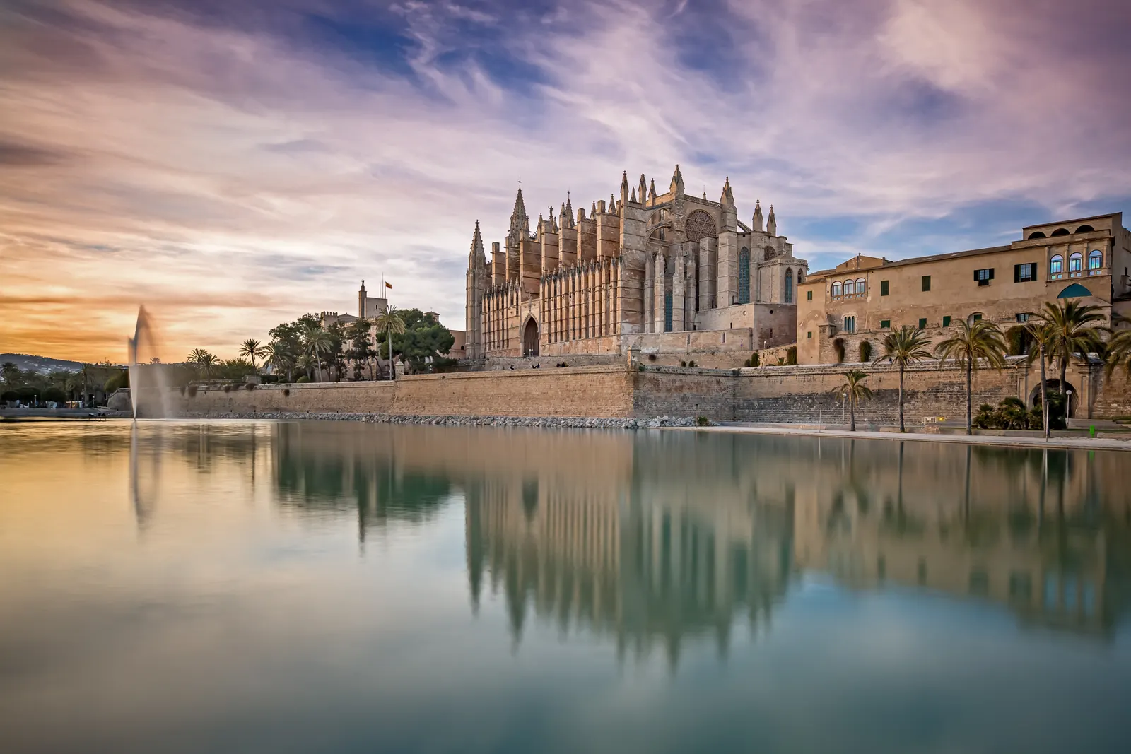 La catedral de La Seu de Palma al atardecer, reflejada en el agua del parque del Mar