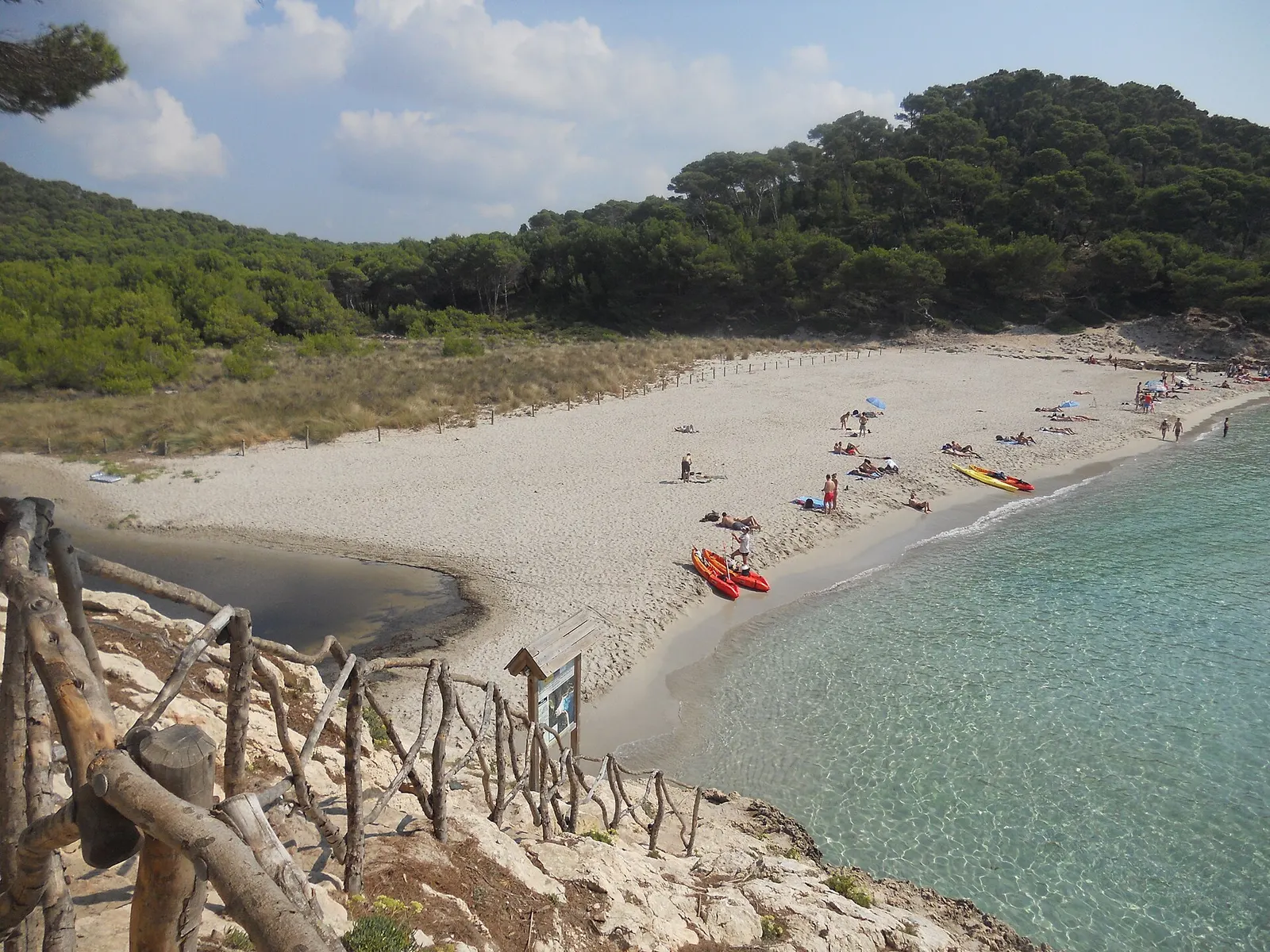 Una cala del sur con la arena clara y una embarcación varada en la orilla