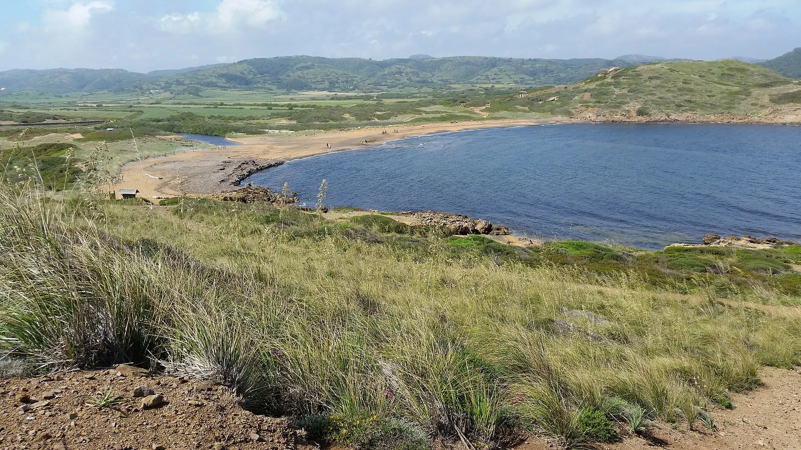La playa de Binimel·là con la laguna detrás y el monte bajo de la costa norte