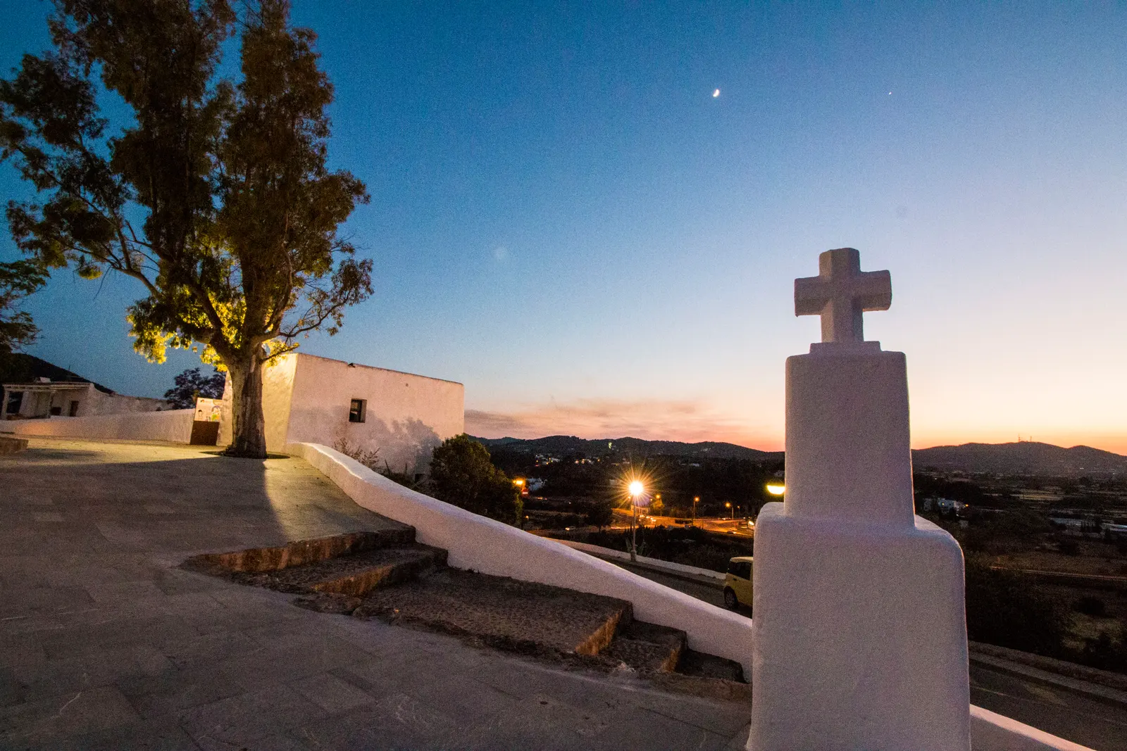 El Puig de Missa de Santa Eulària al atardecer, con su iglesia encalada y la cruz sobre el muro
