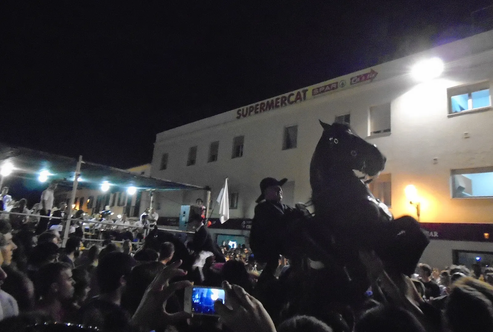 Caballos negros menorquines montados, en el jaleo de una fiesta de pueblo