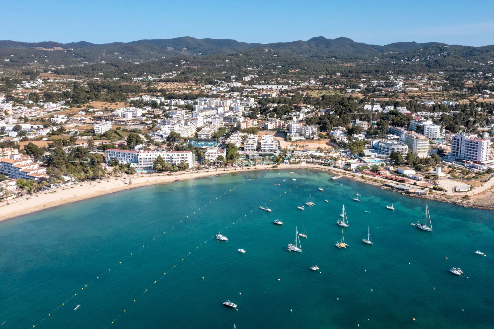 Sant Antoni de Portmany desde el aire, con el pueblo, el frente marítimo y los barcos en la bahía
