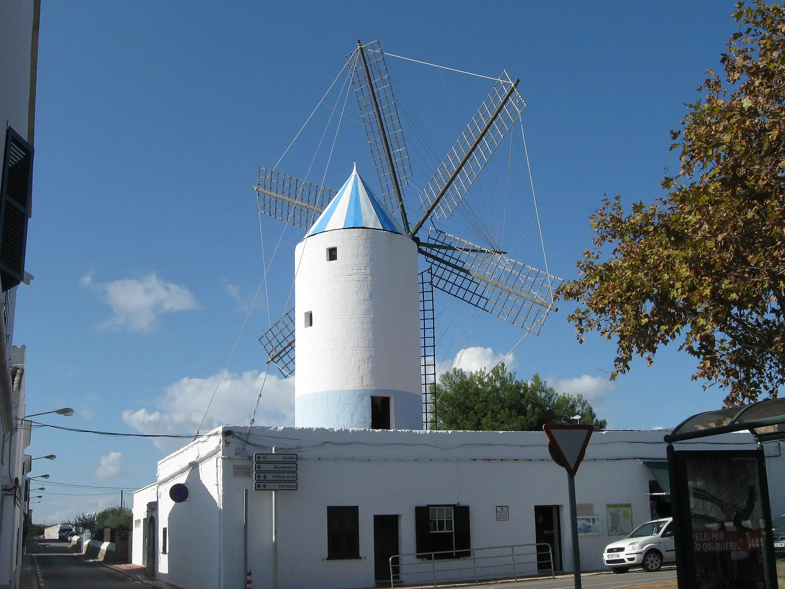 El molino blanco y azul de Sant Lluís sobre las casas del pueblo