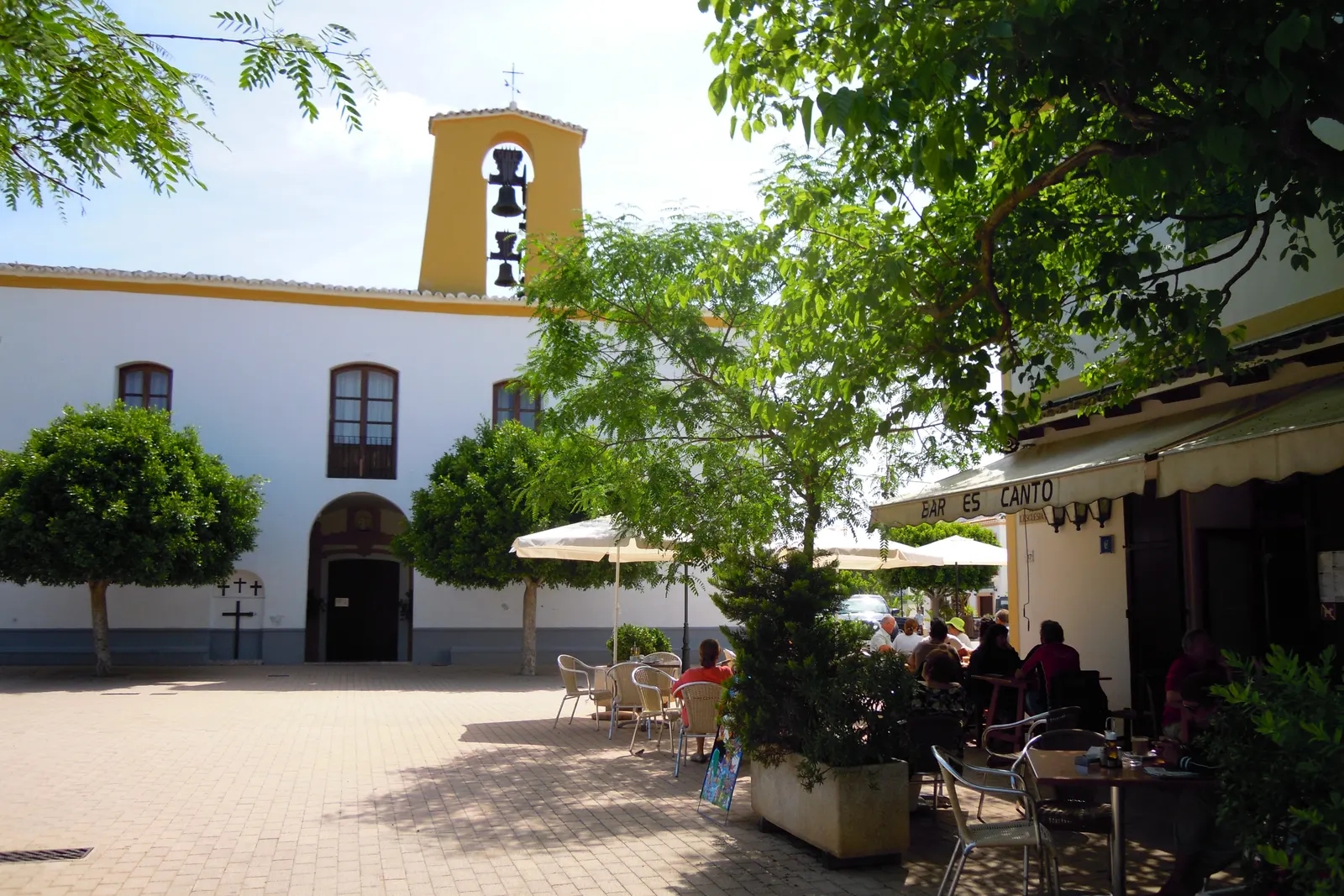 La plaza de Santa Gertrudis de Fruitera, con las terrazas bajo los toldos y la fachada blanca de la iglesia