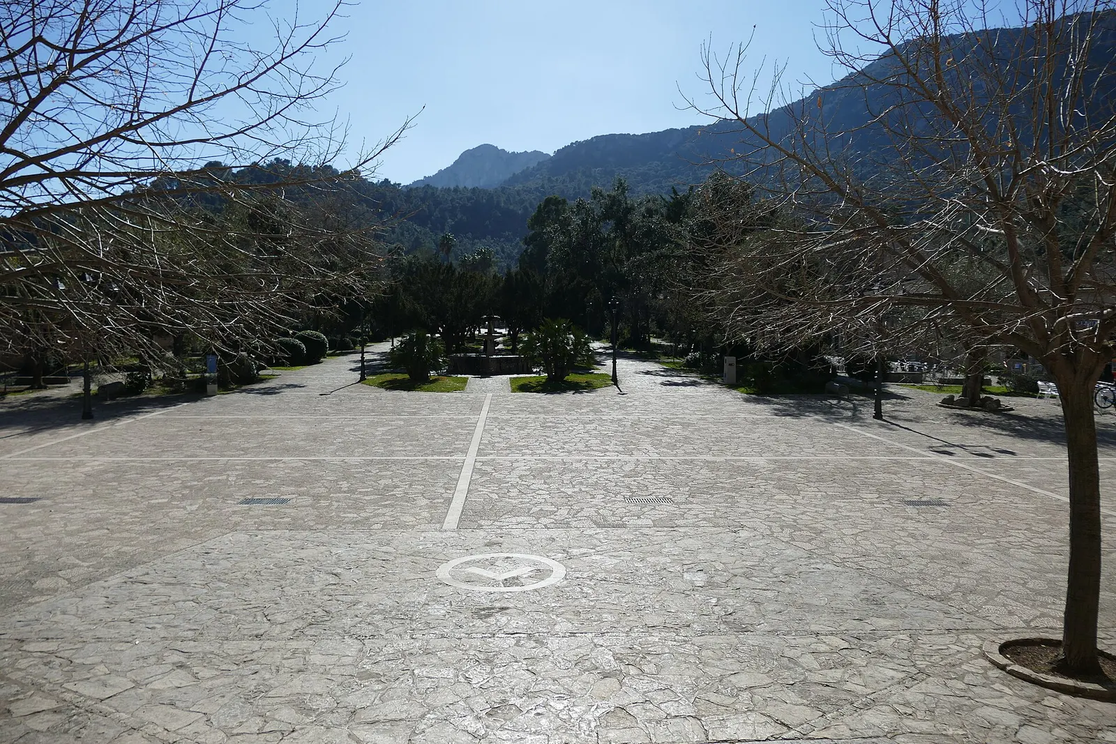 La explanada de entrada al Santuari de Lluc, con sus árboles y la montaña detrás
