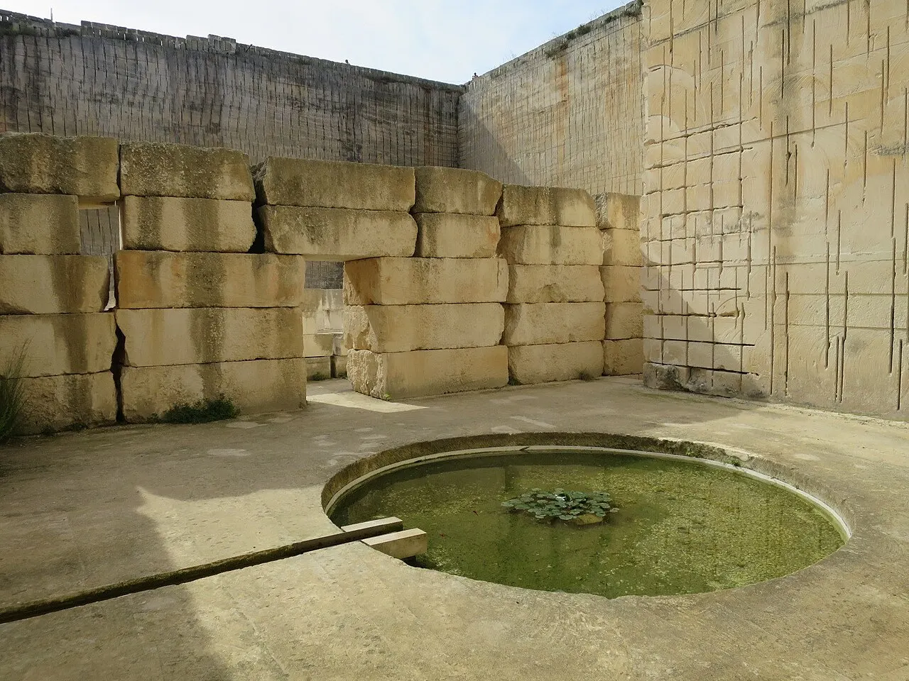 Los muros monumentales de piedra de marés y un estanque en las antiguas canteras de Líthica (Pedreres de s'Hostal), Ciutadella, Menorca.