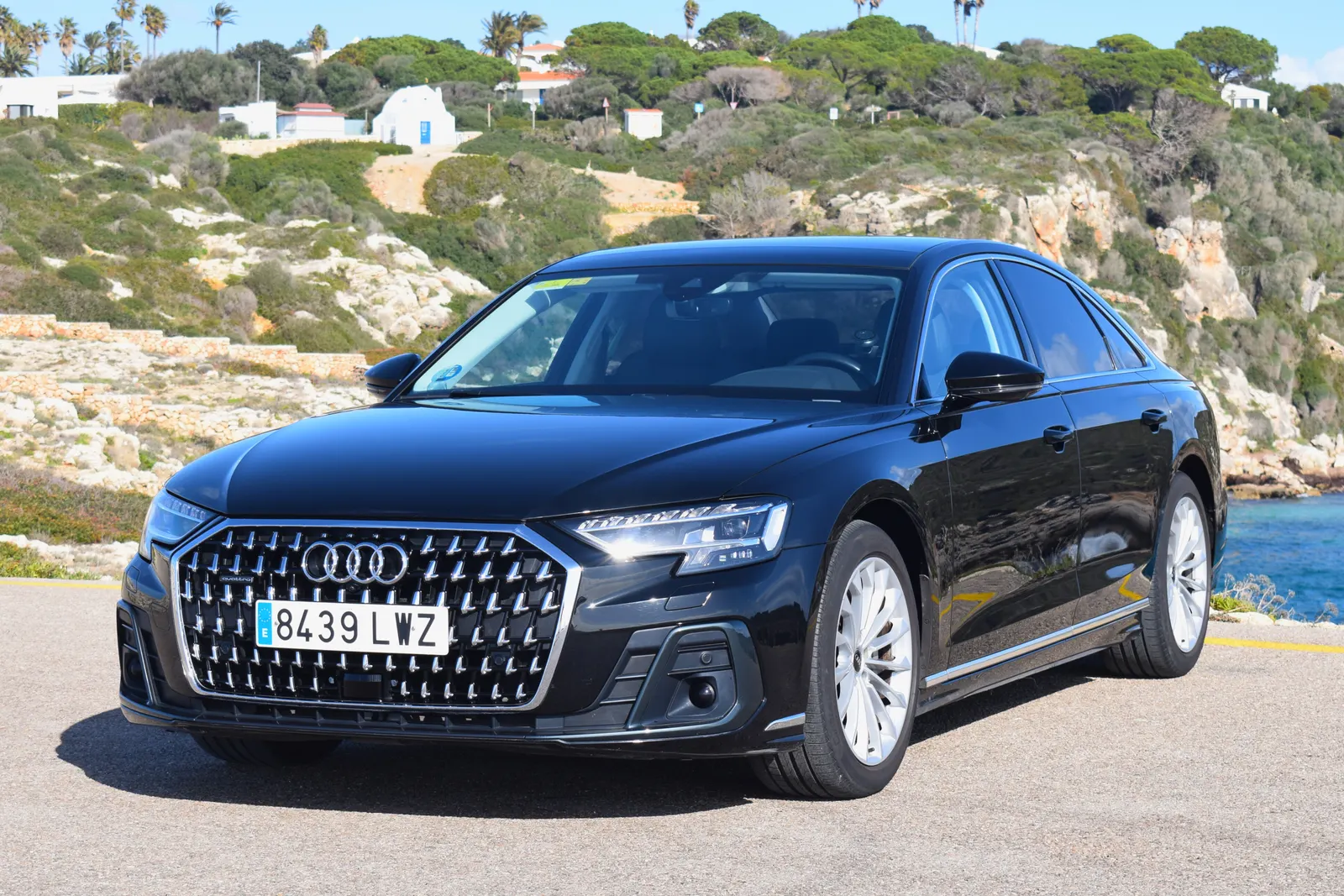 Audi A8 negro de Menorca Bus aparcado junto a una cala de Menorca.
