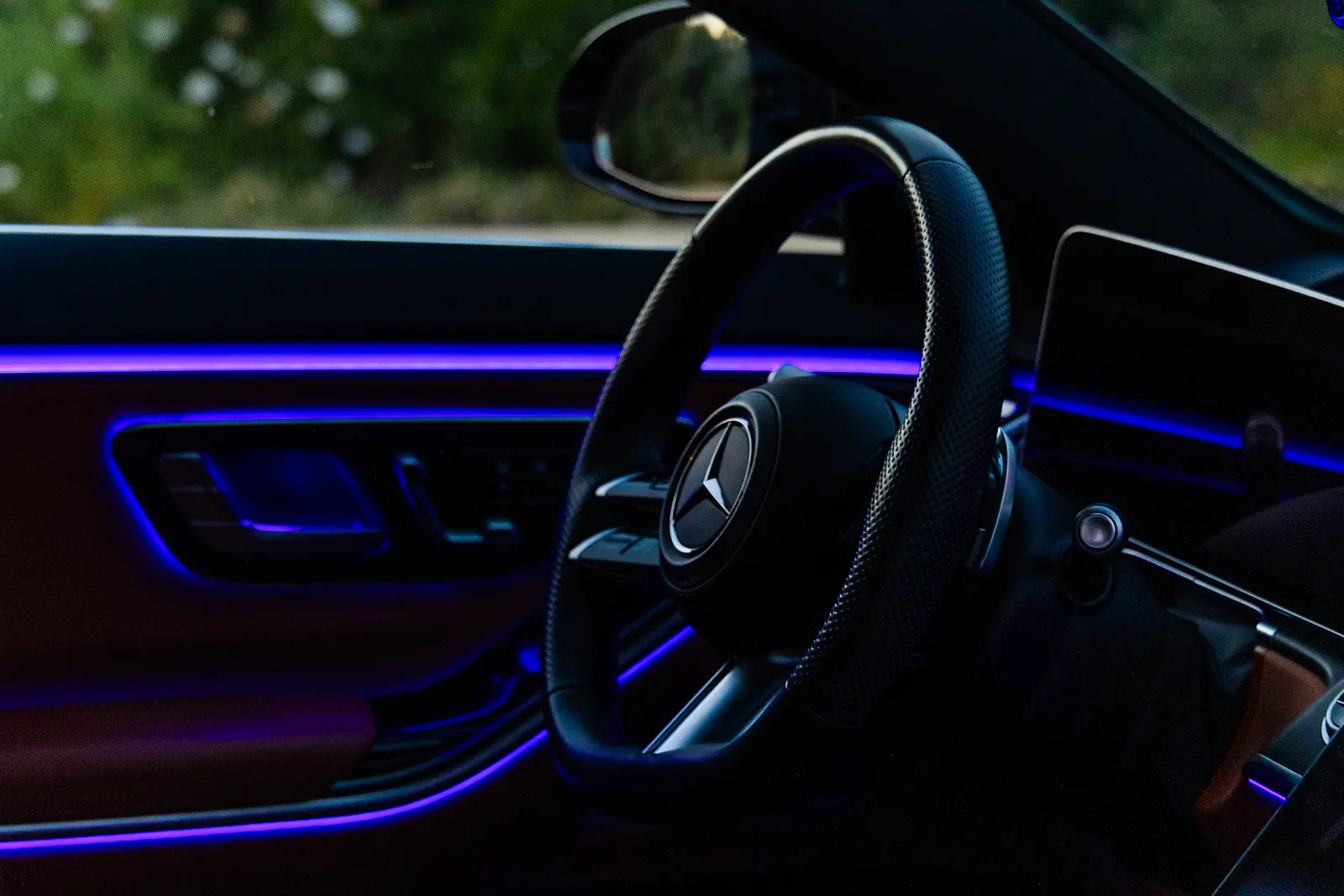 Interior del Clase S de noche, con la iluminación ambiental LED y la estrella iluminada en el volante.