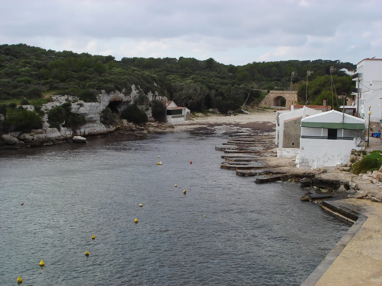 Cala Alcaufar, un pequeño puerto pesquero con casetas de varada encaladas junto al agua.