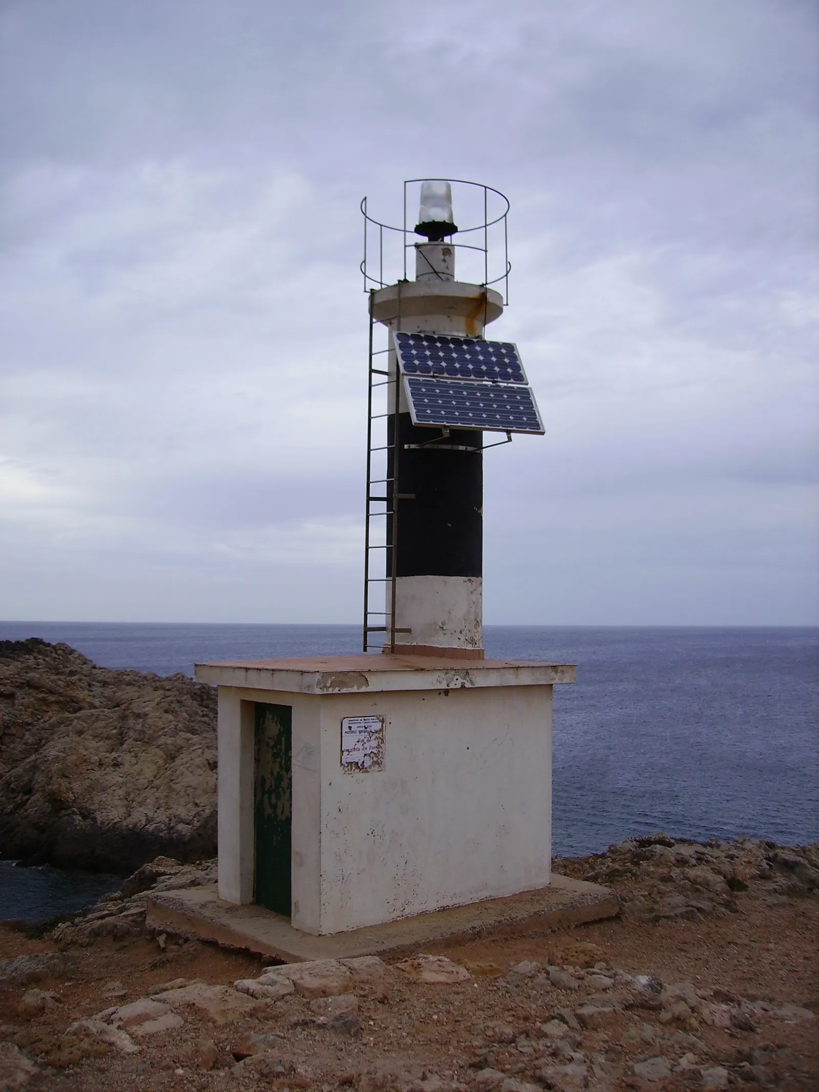 Il piccolo faro di Fornells, dotato di pannelli solari, sulle rocce all'imbocco della baia.