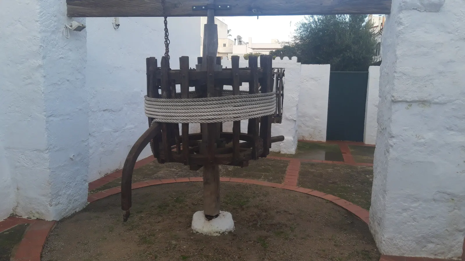 La rueda de una antigua prensa de aceite, en un patio encalado de Sant Lluís.
