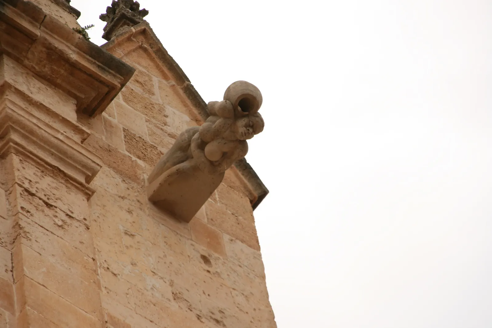 Detalle de una gárgola en la fachada de la Catedral de Ciutadella, tallada en piedra de marés.