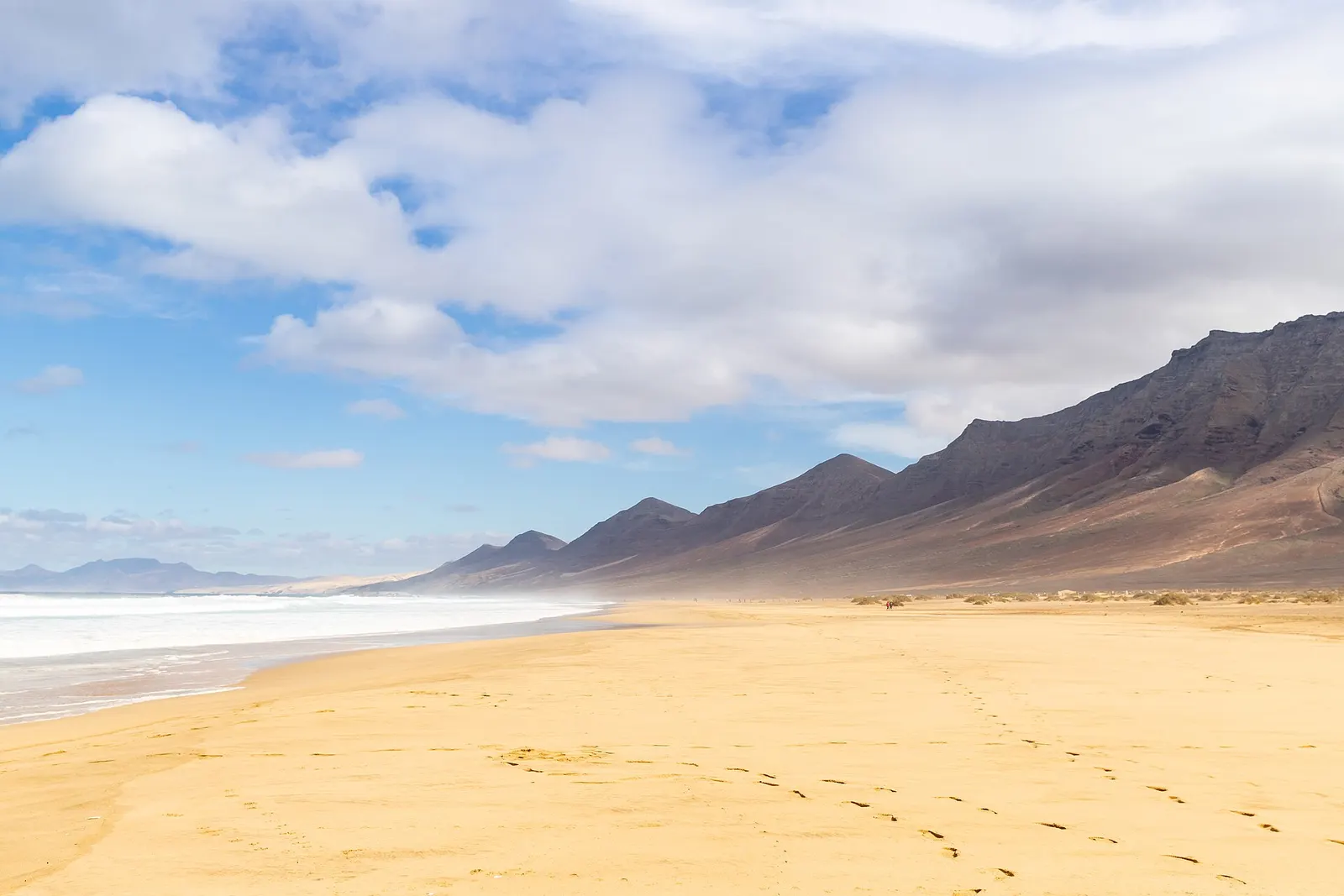 La playa de Cofete, inmensa y vacía, bajo las cumbres oscuras de Jandía y un cielo de nubes que llegan del Atlántico.